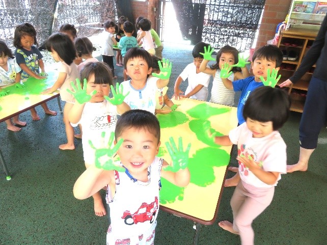 フィンガーペインティングを行う園児の写真