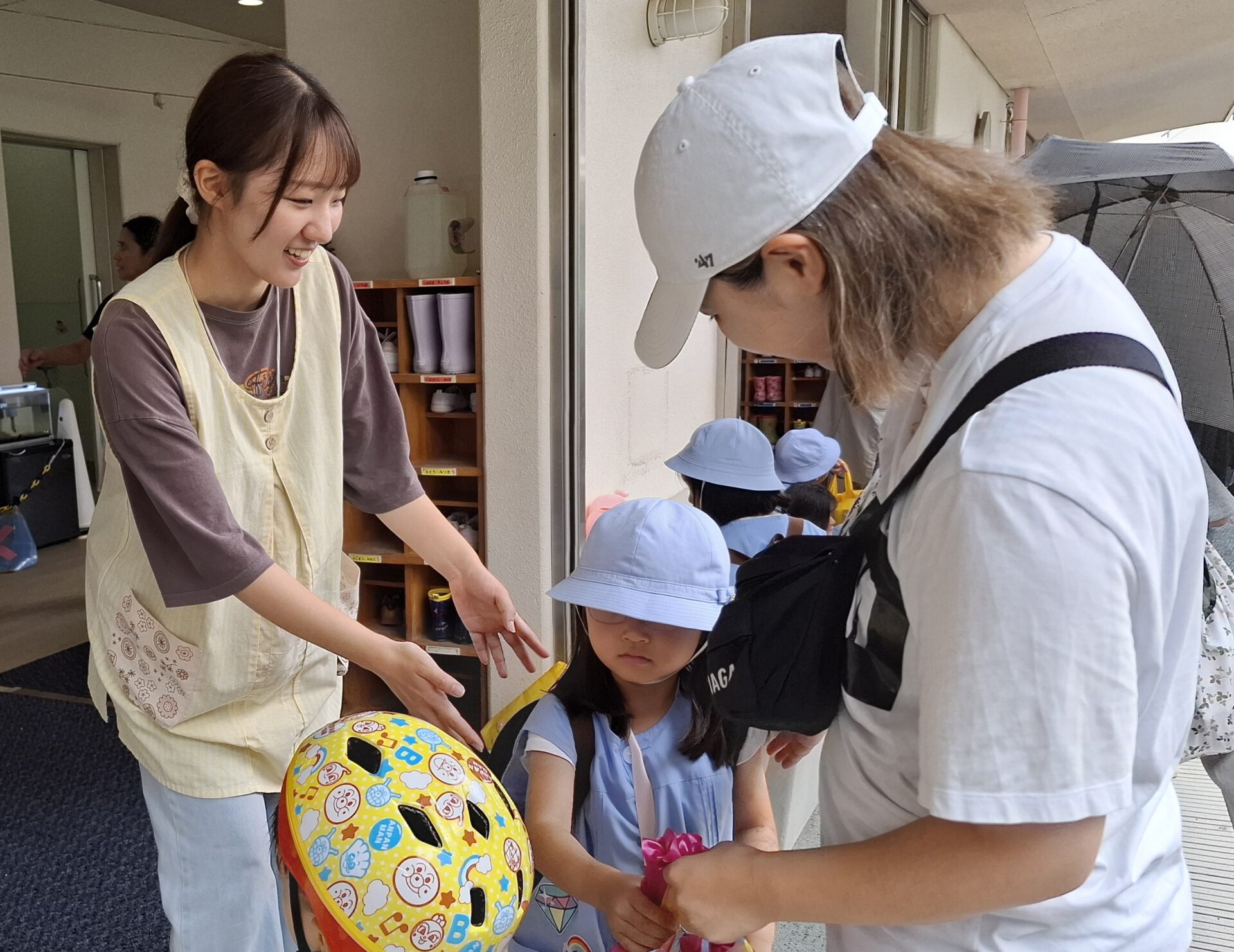 お母さんのお迎えで笑顔になる園児の写真