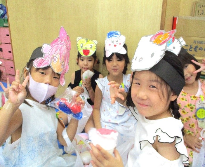作ったお面で遊ぶ園児の写真